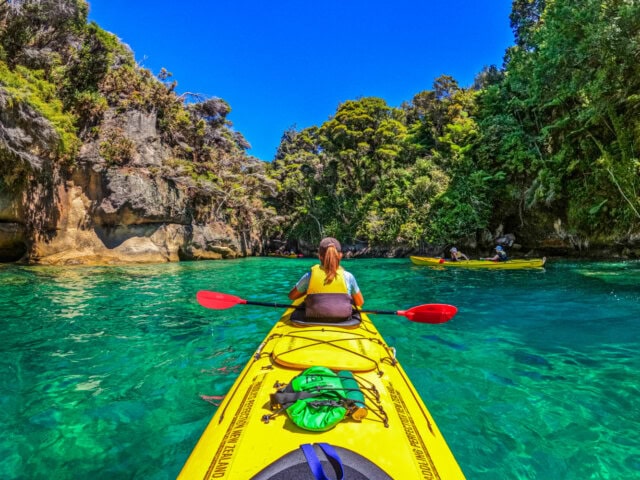 Tourists on a Kayak tour in the Abel Tasman national park on the South Island of New Zealand.