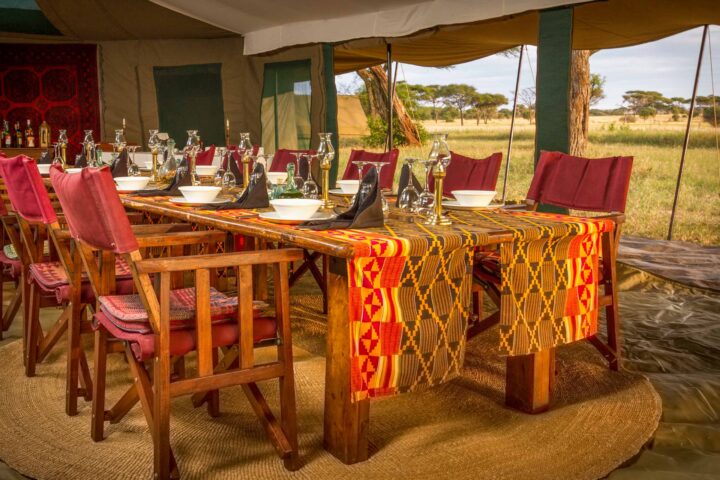 A set dining table in a tent.