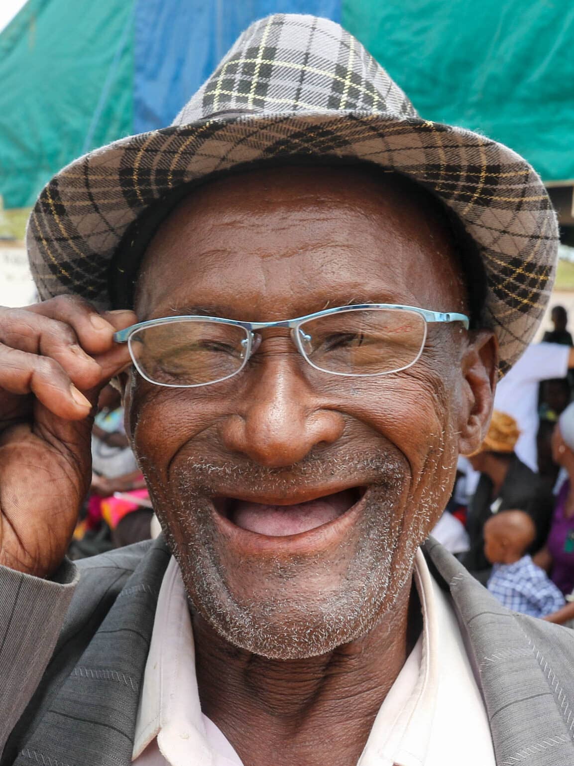 Man in Zimbabwe smiling while wearing new glasses.